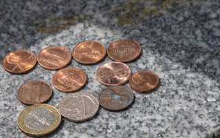 pennies and other coins on top of a headstone