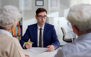 elderly couple sitting in front of a end-of-life planning specialist in a suit