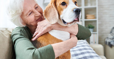 woman smiling while embracing her Beagle dog