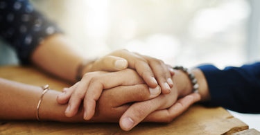 close up of two people's hands being held on a table