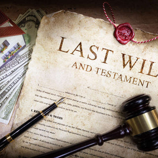 a Last Will and Testament document on a table next to a gable, money, a house trinket and necklace