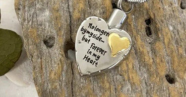 a cremation heart necklace that says "no longer by my side... but forever in my heart"