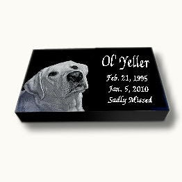 a flat grass level headstone marker with a dog's headshot photo, name, date and the words "sadly missed"