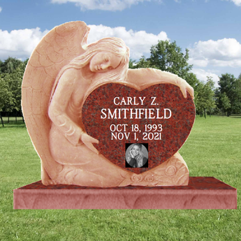 Carved Angel hugging a Single Ruby Red Granite Heart Headstone. In the heart is a last name, and the words "in loving memory", on the base is a first name, middle initial, birth and death date.