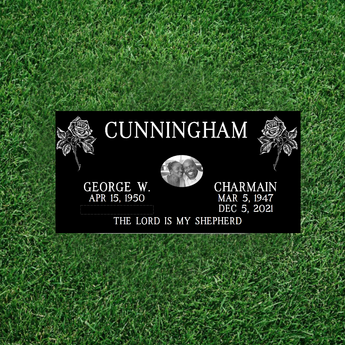 companion flat grass level headstone with two roses in the upper corner,  last name centered. Names and dates on either side of a headshot photo and an epitaph at the bottom